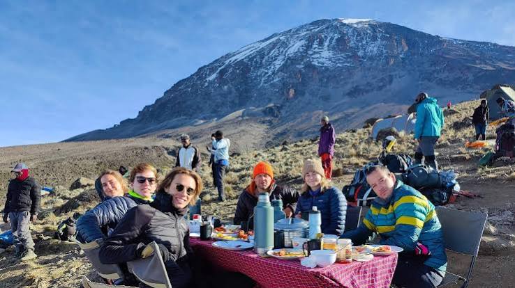 Mount Kilimanjaro hikers enjoying a premium hot meal inside a luxury dining tent