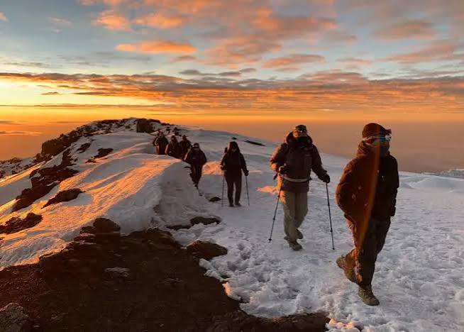 Elite expedition group trekking toward Barafu Camp across vast volcanic fields on Kilimanjaro