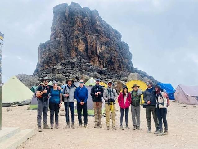 Trekkers scrambling up the iconic Barranco Wall on Mount Kilimanjaro luxury trekking tour