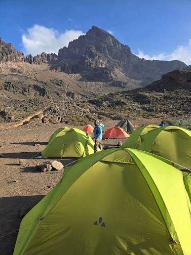 Trekkers arriving at the dramatic Mawenzi Tarn Camp beneath jagged volcanic spires on Kilimanjaro
